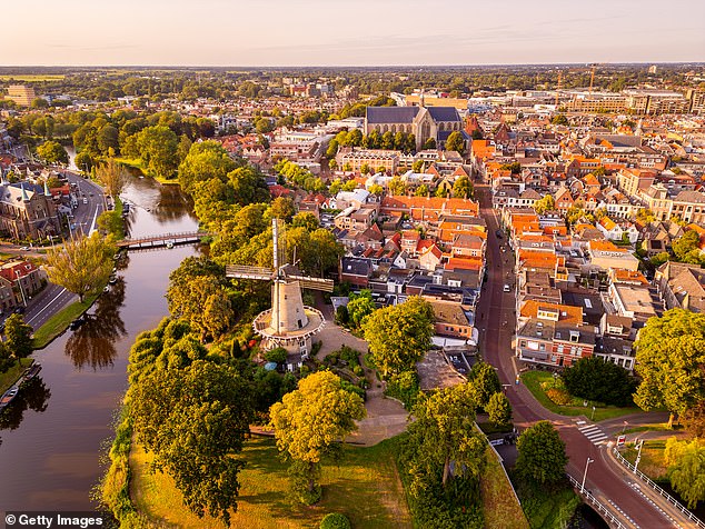 For decades, the Netherlands stuck to the traditional male breadwinner model, until women began entering the workforce in part-time roles during the 1980s and 1990s. Pictured: High angle Drone Point of View on Old Windmill in City Center of Alkmaar, North Holland