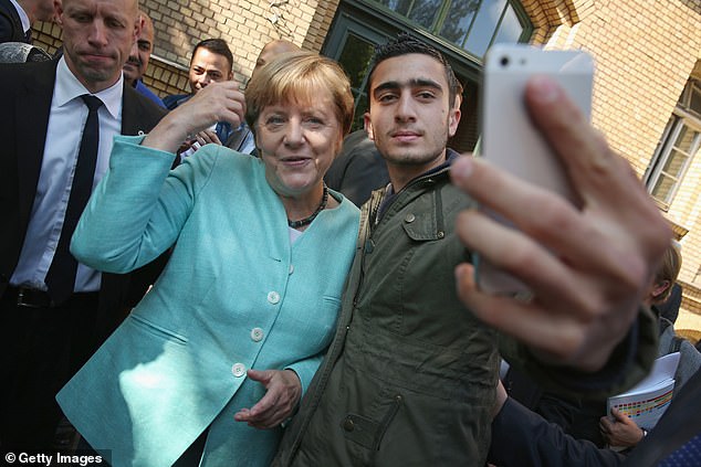 German Chancellor Angela Merkel pictured posing for a selfie with a refugee. Millions entered after the Chancellor's momentous decision in 2015 to open borders to Syrian refugees