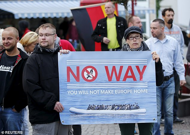 Protesters demonstrating against Mrs Merkel's policies in 2015. Migrants have since been linked to terrorist killings, shootings and sexual assaults, according to the authorities