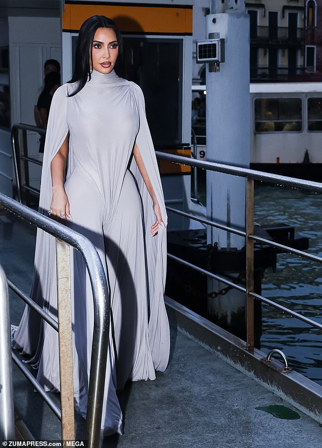 The top portion was actually an elaborate leotard with shoulder pads, a high necklace, and long open sleeves. It came down over her wide-legged slacks, which is a first for her