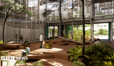 Artist's impression of part of a new hospital, showing outdoor garden with seating, and glass-fronted buildings behind.