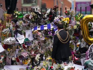 The lord mayor of Birmingham Zafar Iqbal views the messages and floral tributes left at the Black Sabbath Bridge bench on Broad Street in Birmingham in memory of Black Sabbath frontman Ozzy Osbourne