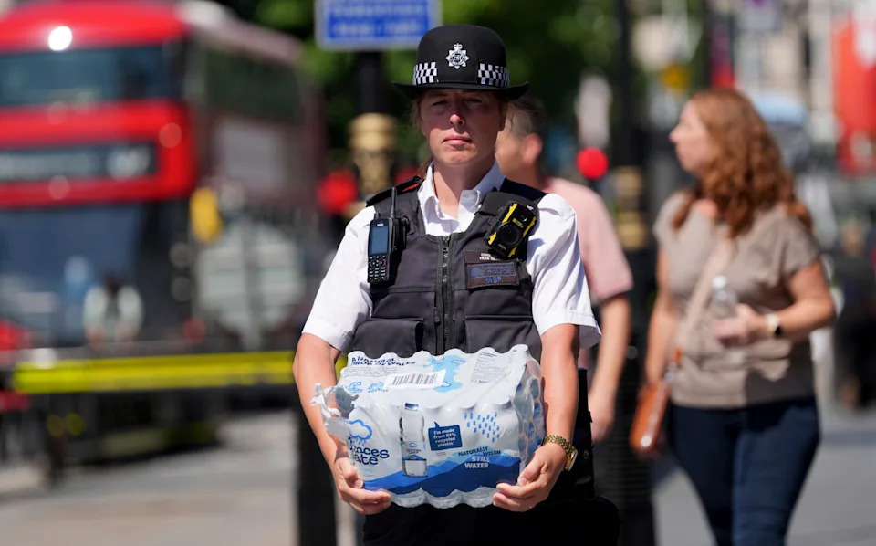A police officer carries bottles of water through Westminster