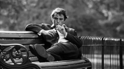 Getty Images Terence Stamp sitting smoking on a park bench