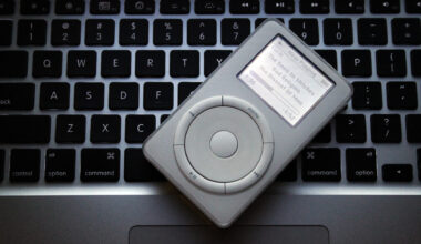 An Apple iPod resting on top of an Apple Mac laptop to showcase the different technologies.