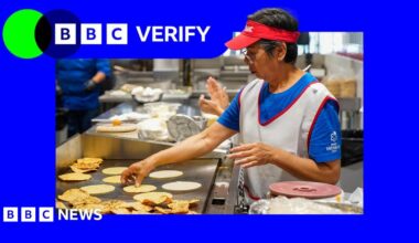 A woman flipping tortillas on a grill in a restaurant kitchen in America