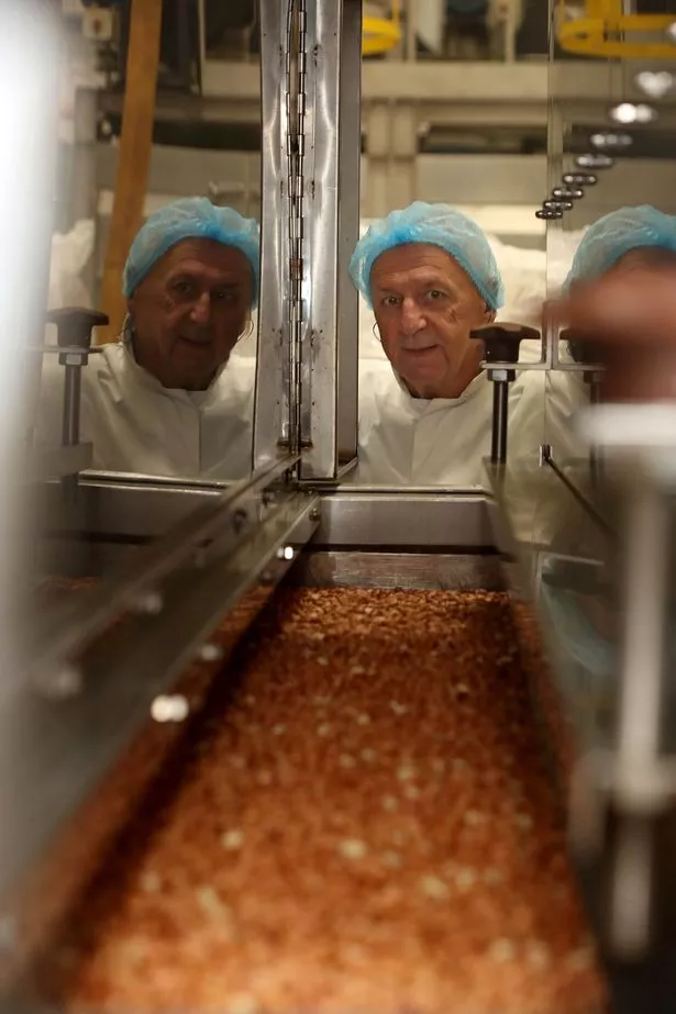 This shot shows a Chris looking over the top of a roaster, checking the nuts