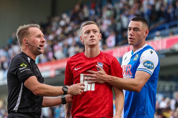  Birmingham City's Jay Stansfield is held by Blackburn Rovers' Lewis Miller and Referee Oliver Langford after he had a coke bottle thrown at him at the end of the match during the Sky Bet Championship match between Blackburn Rovers and Birmingham City at Ewood Park on August 16, 2025 in Blackburn, England. (Photo by Lee Parker - CameraSport via Getty Images)