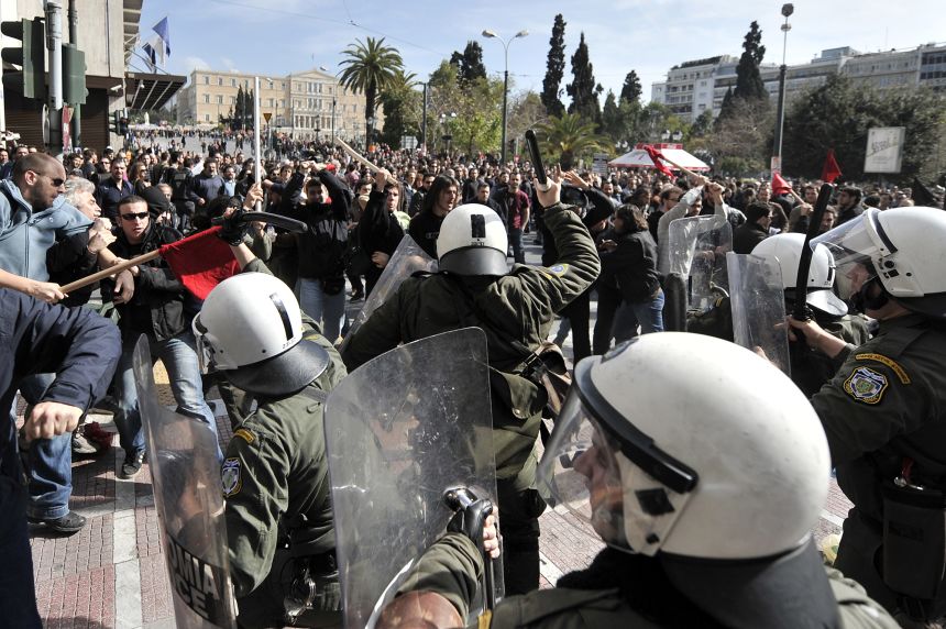 Protesters clash with riot police during a demonstration in the center of Athens on February 24, 2010. Greece ground to a halt on February 24 as unions staged a one-day general strike and thousands of demonstrators took to the streets to protest austerity measures designed to tame a public debt crisis. Schools, government offices and courthouses were all closed while there was also major disruption to public transport, banks, hospitals and state-owned companies.