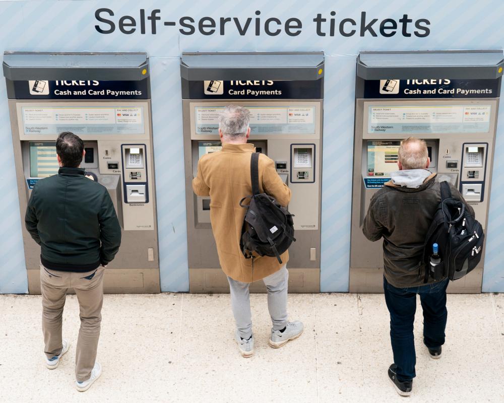 People use a ticket machine at Waterloo railway station in London.