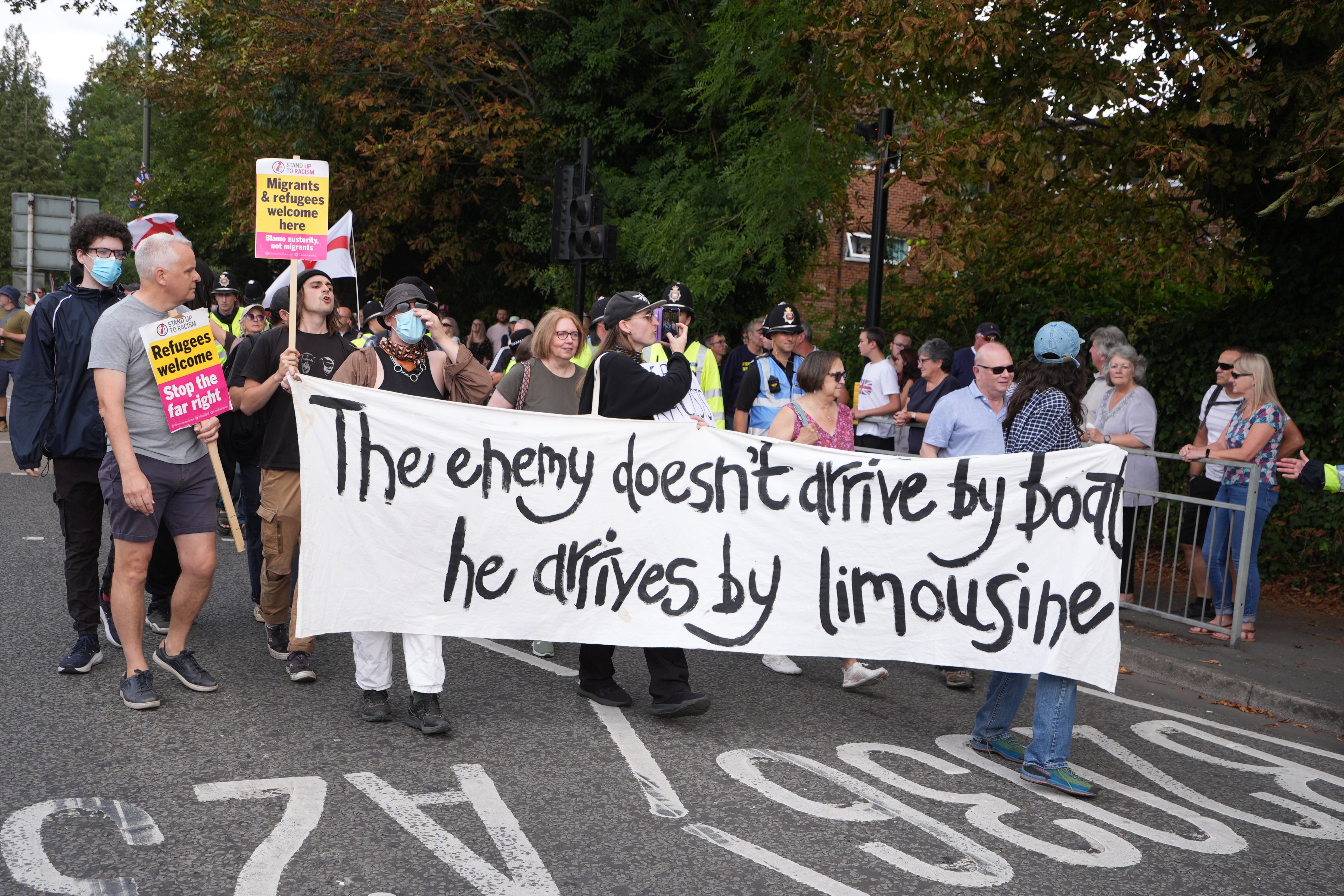 People take part in a Stand Up To Racism rally outside the Sheraton Four Points Hotel in Horley