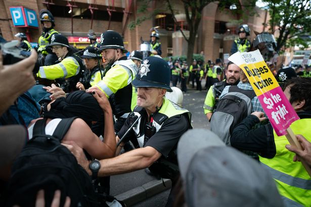 Police officers scuffle with demonstrators during a protest at Castle Park