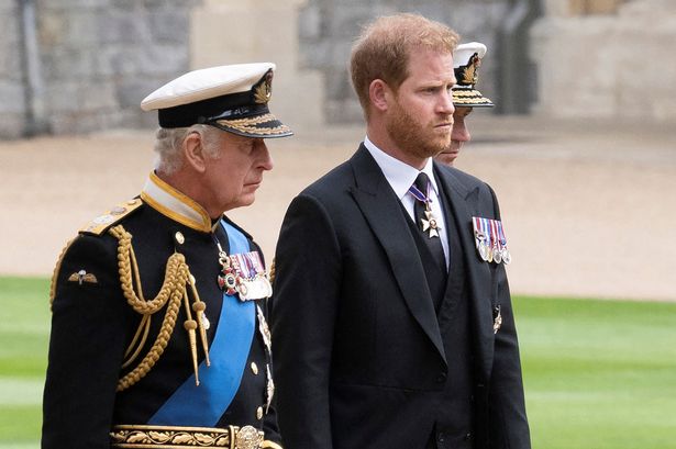Britain's King Charles III (L) walks with his son Britain's Prince Harry,