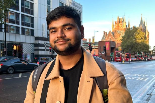 Shaurya wearing a brown coat, looking at the camera, smiling