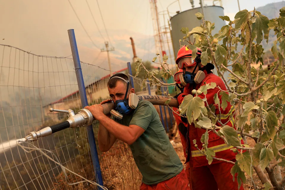 Firefighters spray water on a wildfire near the town of Delvine, south-east Albania, on August 13, 2025. (Photo by Adnan Beci / AFP) (Photo by ADNAN BECI/AFP via Getty Images)          