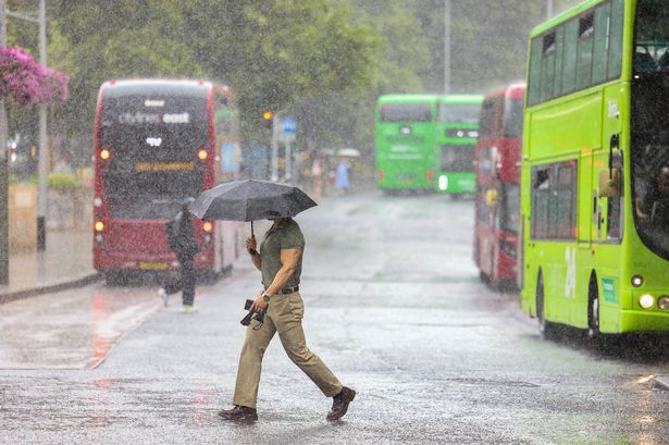 A pedestrian crossing the street in stormy weather 
