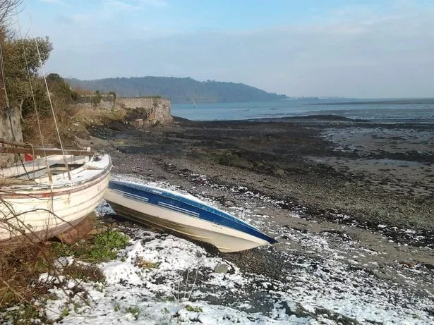 A boat on the shore of the Menai Strait