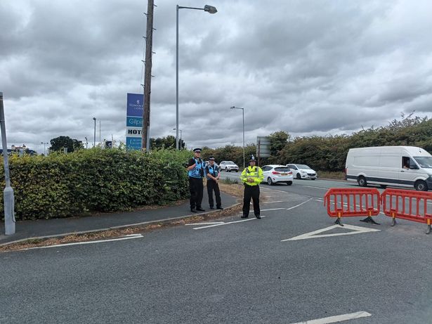 Police officers observing outside Roman Way Hotel along the A5 in Cannock