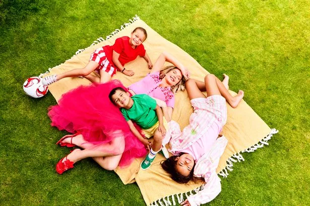 Helen flanagan lying on a picnic blanket in garden with her kids