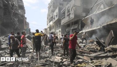 Gazans assess destruction following the Israeli attack on Zeitoun. Buildings have pancaked to the side of the street.