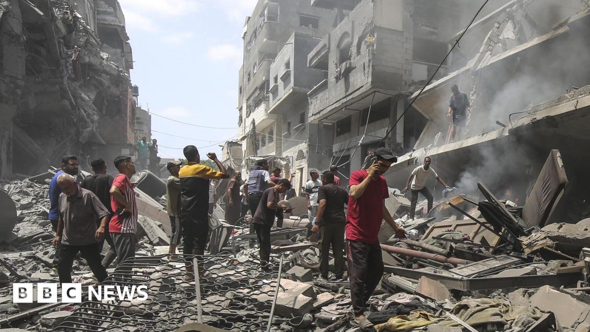 Gazans assess destruction following the Israeli attack on Zeitoun. Buildings have pancaked to the side of the street.