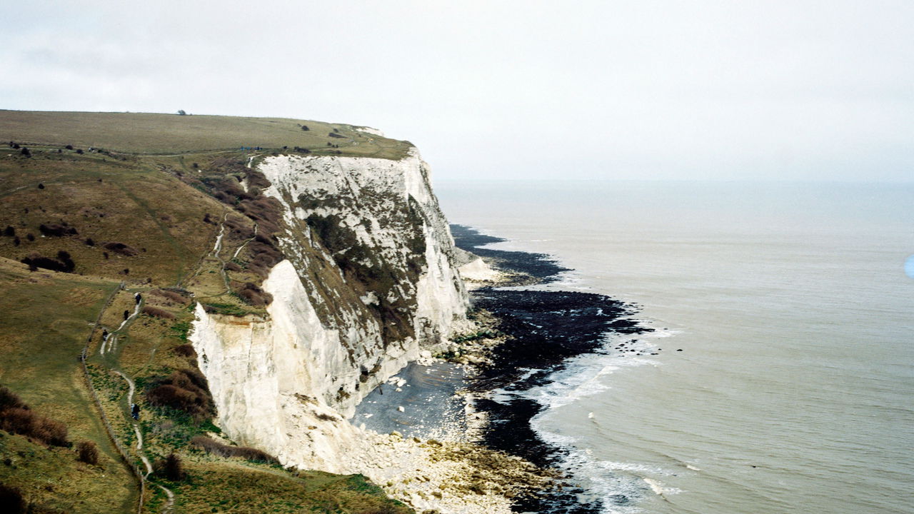 People walking a coastal path along the White Cliffs of Dover.