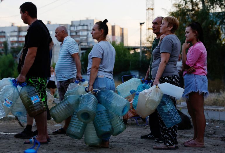 Local residents wait in line to collect water delivered by a tank truck in the course of Russia-Ukraine military conflict, in Donetsk, a Russian-controlled city of Ukraine, August 21, 2025. REUTERS/Alexander Ermochenko