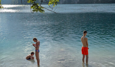 A young man and a young woman stand in the shallow waters of the Bavarian Alps