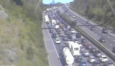 A traffic camera image of the motorway, which shows extremely heavy traffic across four lanes. Cars, caravans and lorries can be seen queuing on the road.