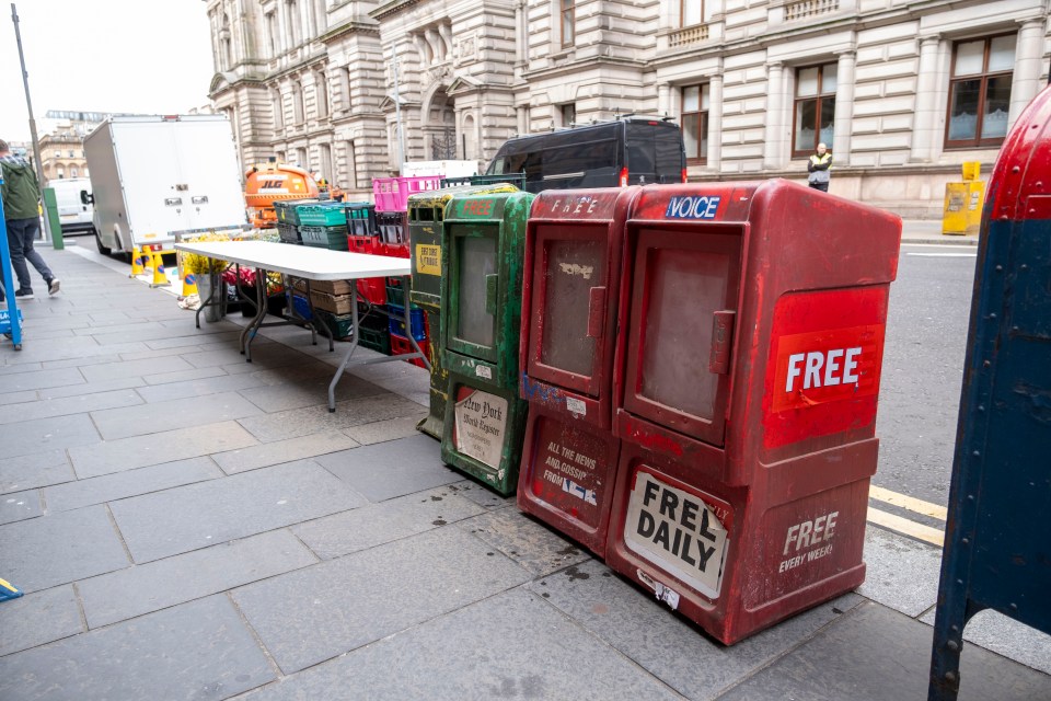Newspaper boxes on a city street.