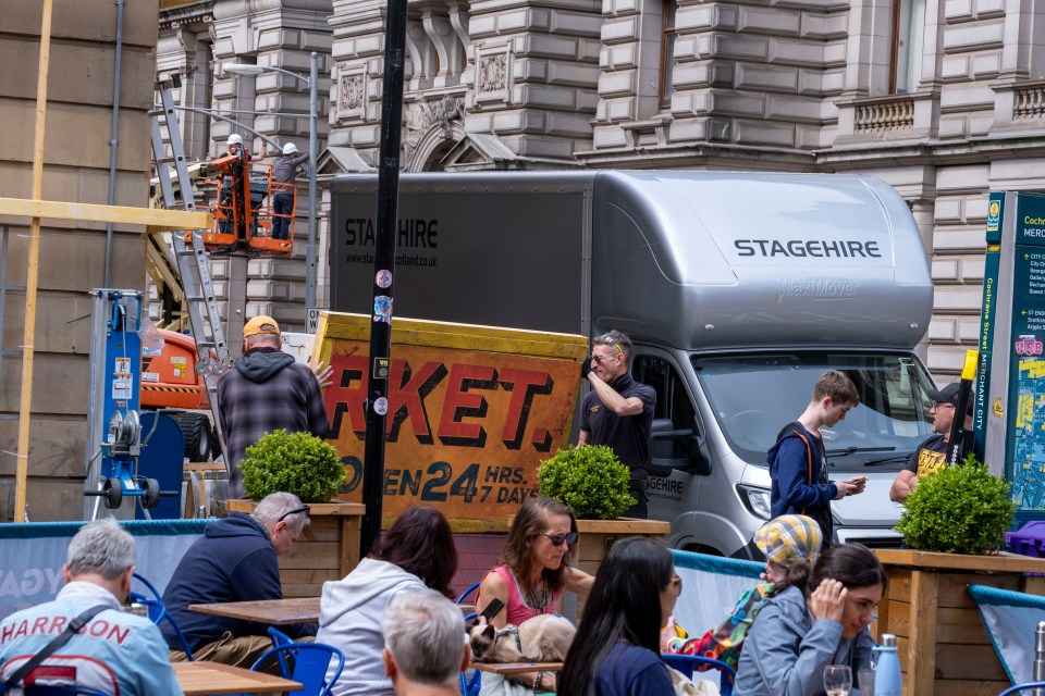 Film crew setting up a "Rocket" sign in Glasgow.