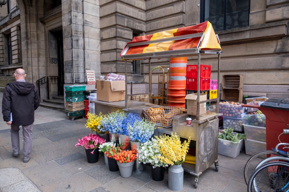 Film set in Glasgow, featuring a flower and food stand.
