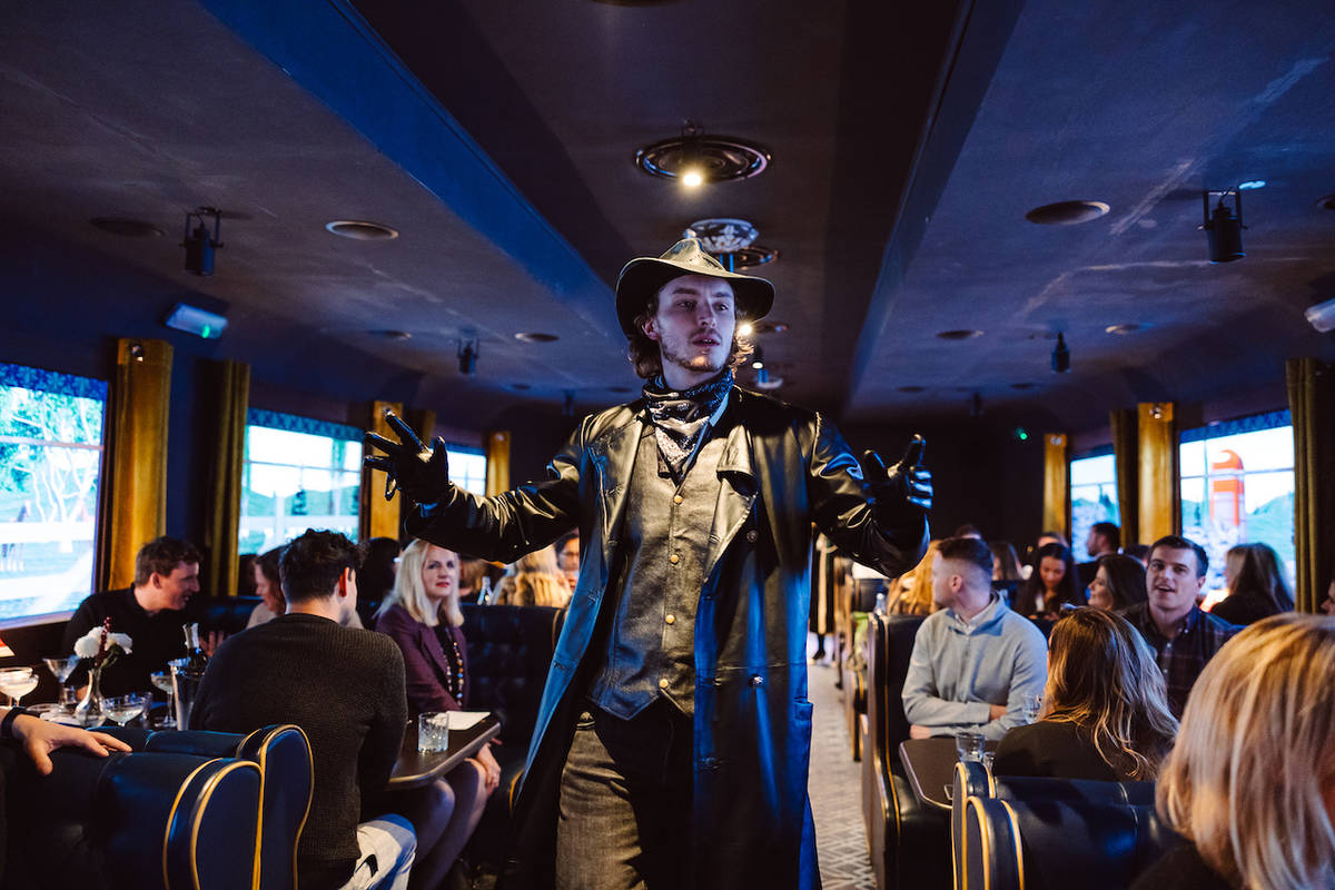a man in 1920s wear strolling down the carriage on The Murder Express