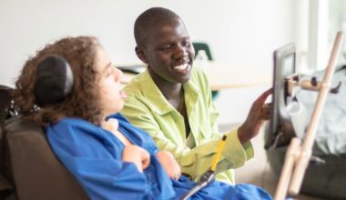 A person using an assistive device for another person in a wheelchair.
