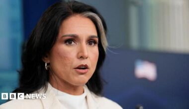 Director of National Intelligence (DNI) Tulsi Gabbard, wearing a white suit over a white shirt, speaks during a press briefing, at the White House in Washington.