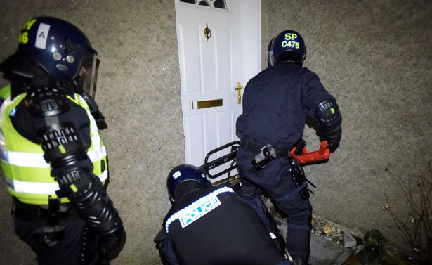 Police Scotland officers raid a property