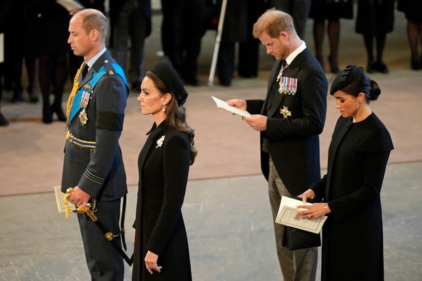 Prince William, Prince of Wales, Catherine, Princess of Wales, Prince Harry, Duke of Sussex and Meghan, Duchess of Sussex pay their respects inside the Palace of Westminster during the Lying-in State of Queen Elizabeth II on September 14, 2022 in London, England.