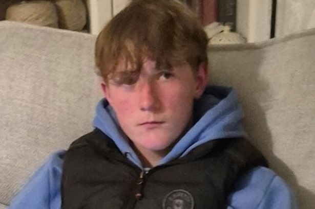 A young mal wearing a blue jumper and black jacket