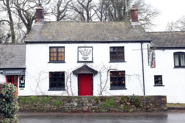 A cheery looking pub, white with a red door