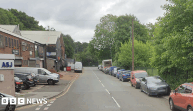 A google street view imagine of a road on an industrial estate with cars parked on the right hand side kerb