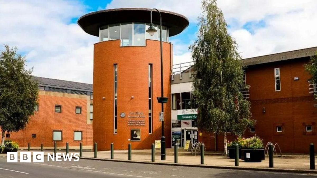 The exterior of the Champney Treasure House, which houses Beverley Art Gallery. The bricks are a terracotta colour and the front of the building is a cylindrical shape with a row of windows around the top and a flat, dark roof.