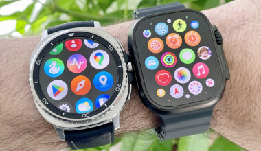 Close-up of a user's wrist wearing both the Samsung Galaxy Watch 8 Classic (left) and Apple Watch Ultra 2 in front of some green foliage