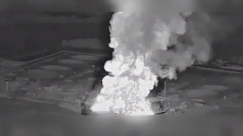 Telegram/Madyar Black and white image of an explosion at an oil pumping station