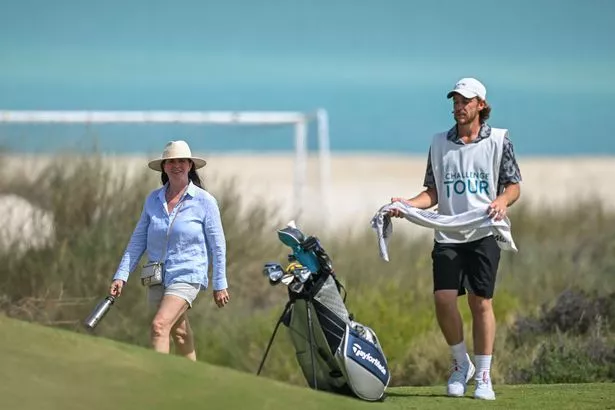 Clare Fleetwood (L) wife of Tommy Fleetwood caddying (R), watching their son Oscar Craig during day one of the UAE Challenge at Saadiyat Beach Golf Club on April 25, 2024 in Abu Dhabi, United Arab Emirates.