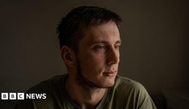 Pavlo, dark-haired and dressed in a green T-shirt, looks away from the camera