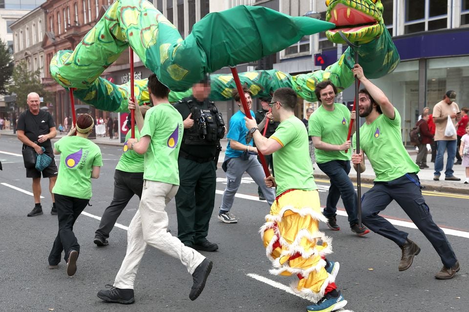 Revellers dance around a PSNI officer during the Mela Carnival. Pic: Press Eye