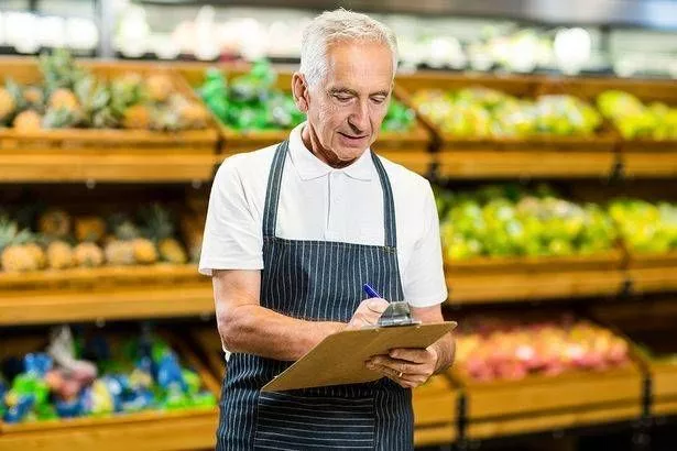An elderly man is working in a supermarket 
