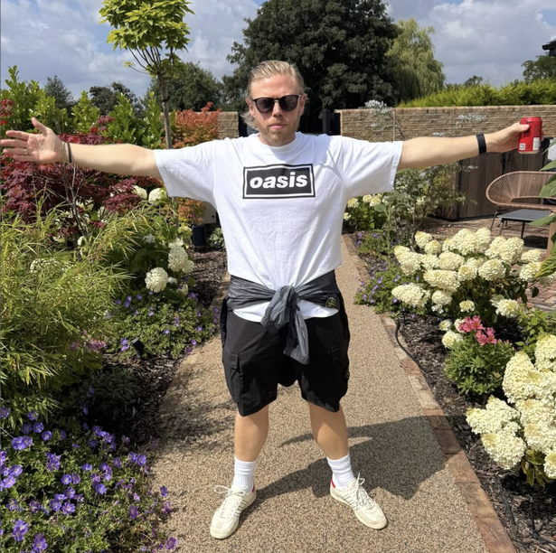 Rob Beckett posing in an Oasis T-shirt