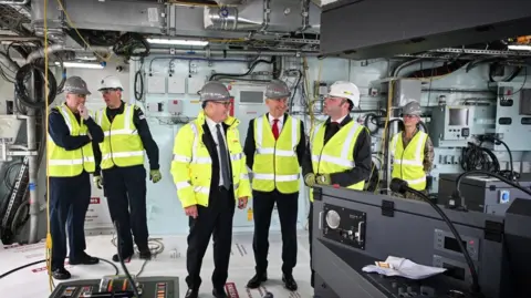 PA Media Prime Minister Sir Keir Starmer and Defence Secretary John Healey listen to Type 26 Programme Director, BAE Systems David Shepherd during a visit to BAE Systems in Govan, Glasgow