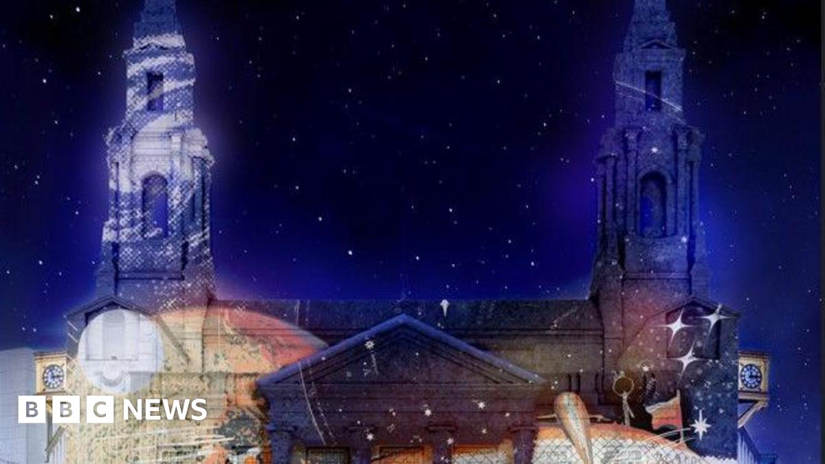 A light display projected to the walls of Leeds Civic Hall. The night sky is filled with stars.